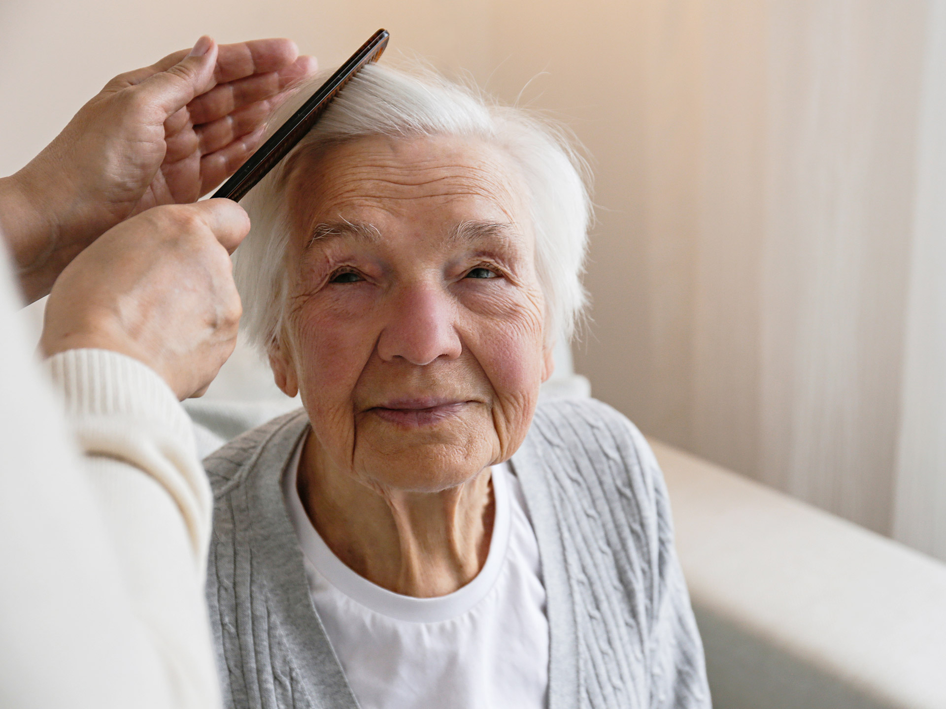 Einer Bewohnerin werden die Haare gekämmt
